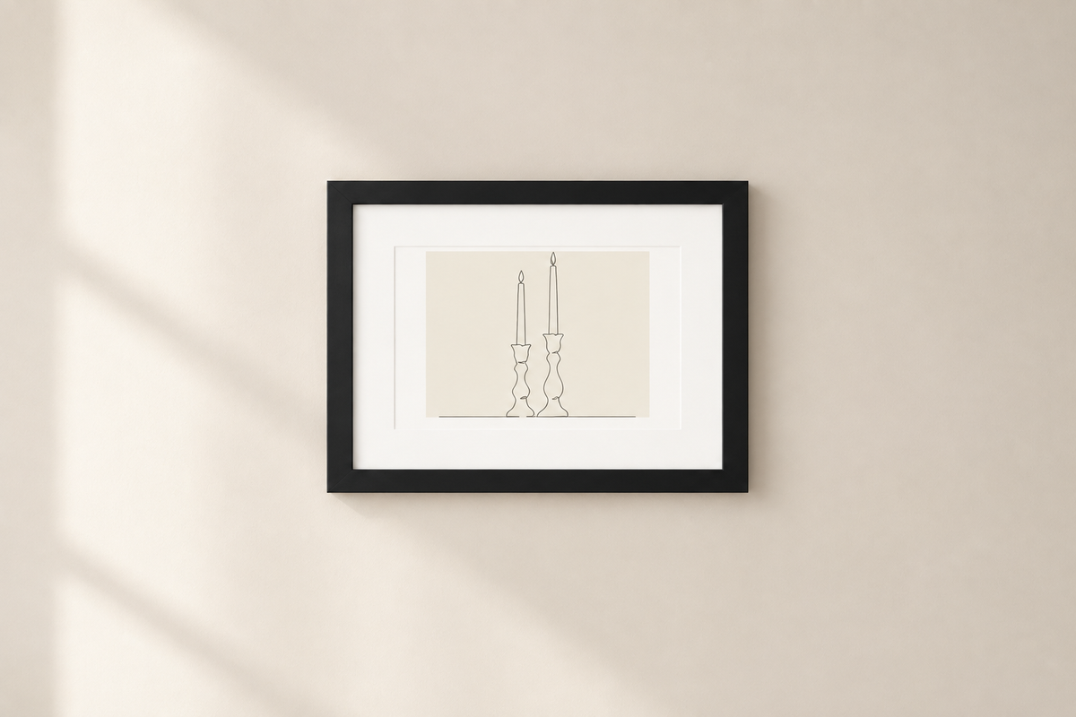 A minimalist black-framed art print featuring a thin line drawing of two candlesticks on a cream background, mounted on a warm beige wall with soft diagonal shadows.